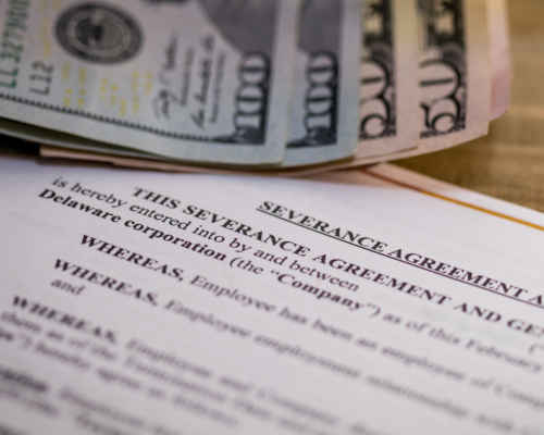 A stack of money next to a paper reading 