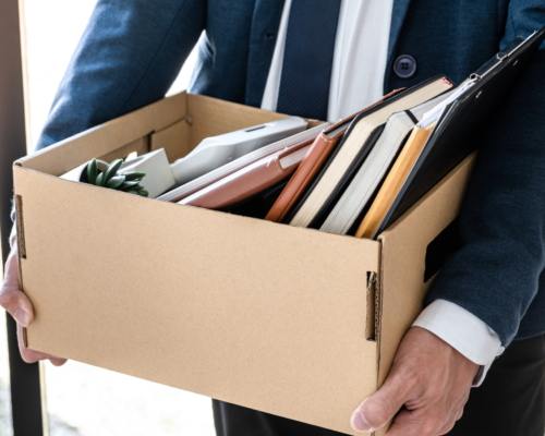 Someone holding a box of their stuff after being fired.