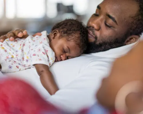 Father holding his baby in arms at home